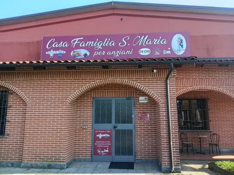 L'ingresso della Casa Famiglia S. Maria: portico in mattoni con archi e insegna bordeaux